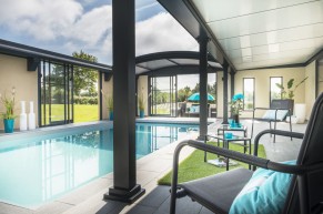 Abri de piscine haut avec espace détente autour de la piscine