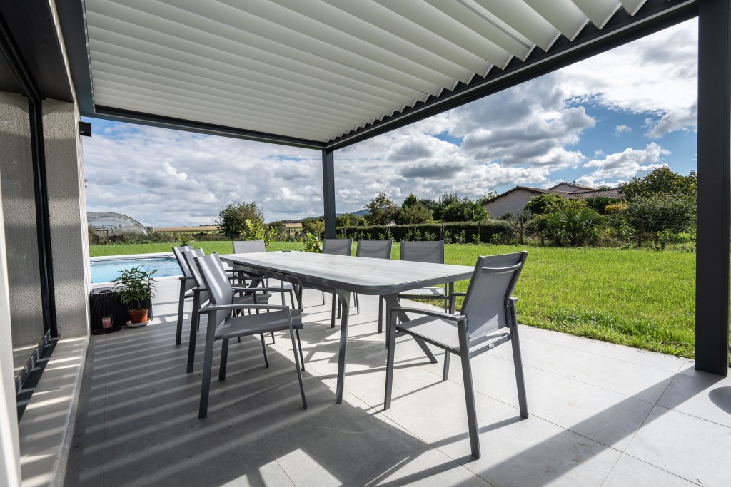 Pergola bioclimatique en aluminium avec salon de jardin