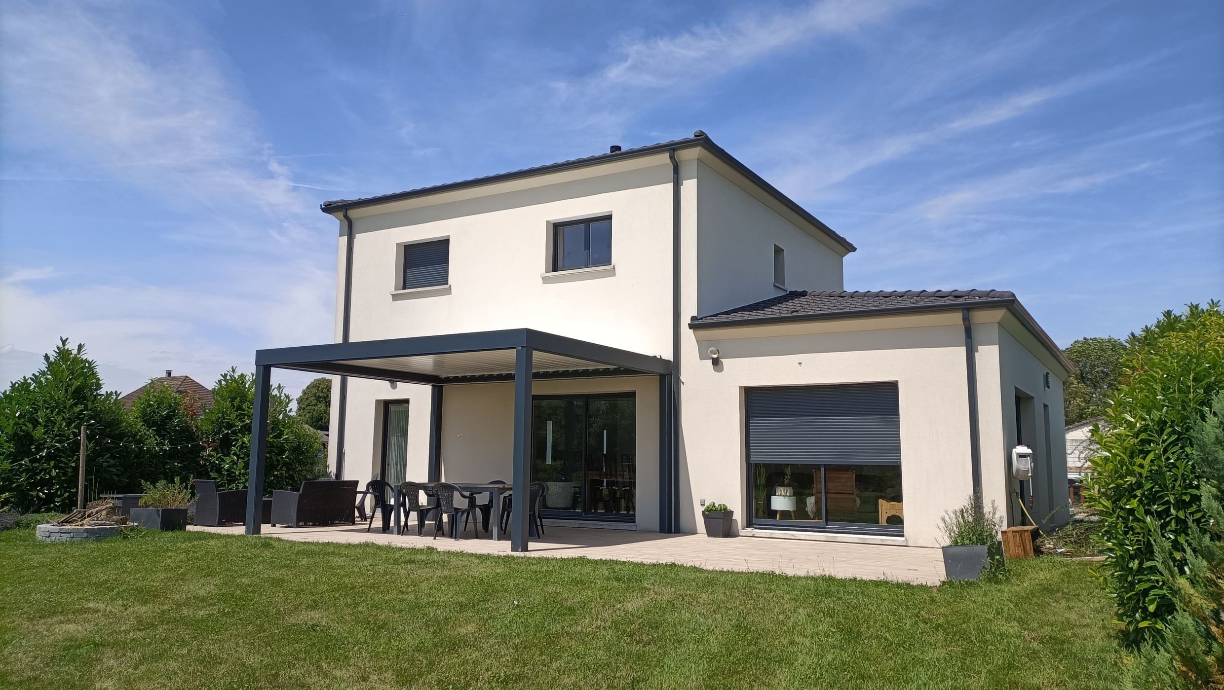 Pergola bioclimatique en aluminium adossée à une maison moderne