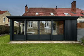 Véranda avec de larges baies vitrées ouverte sur l