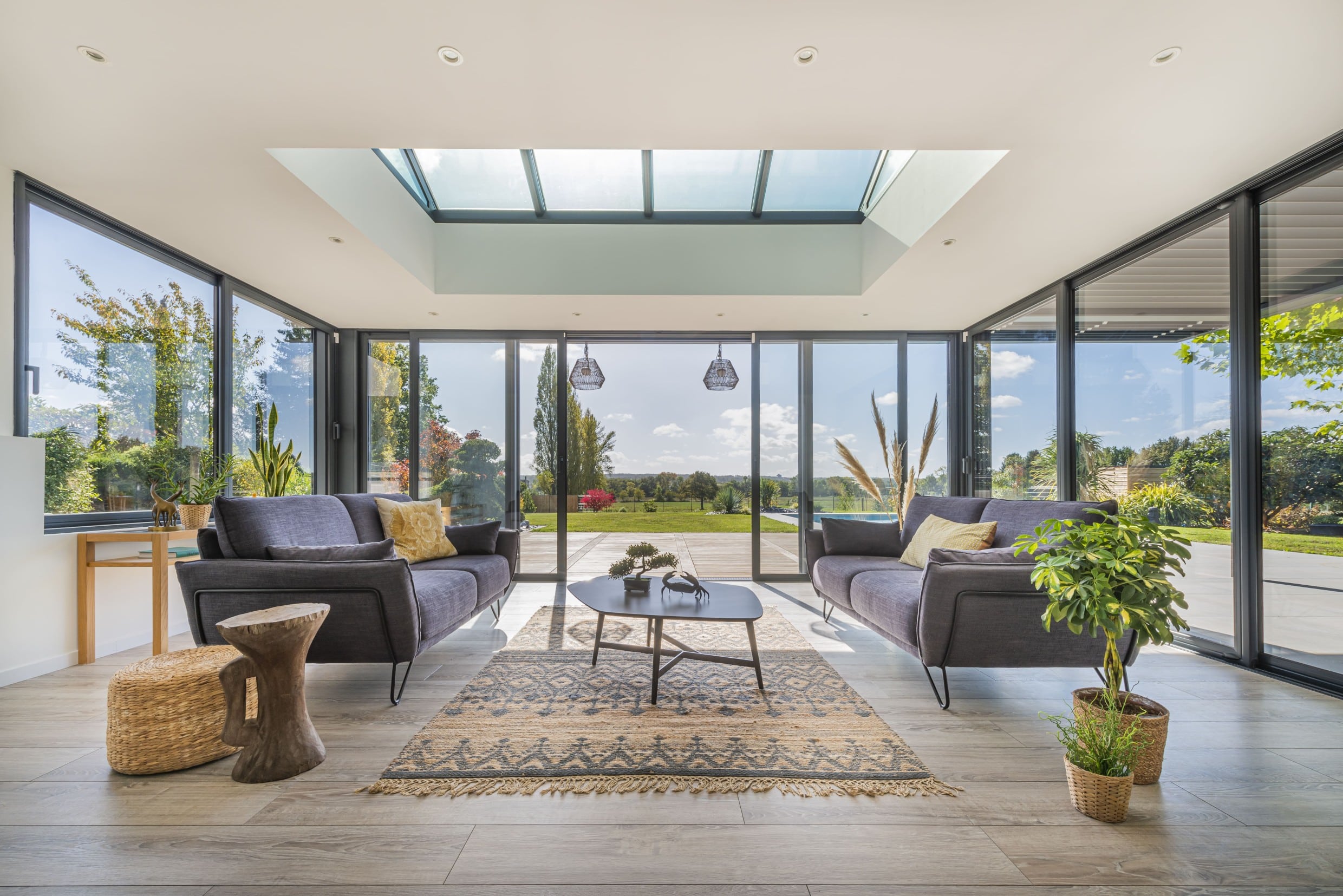 Extension en aluminium ouverte sur l'extérieur avec un aménagement salon