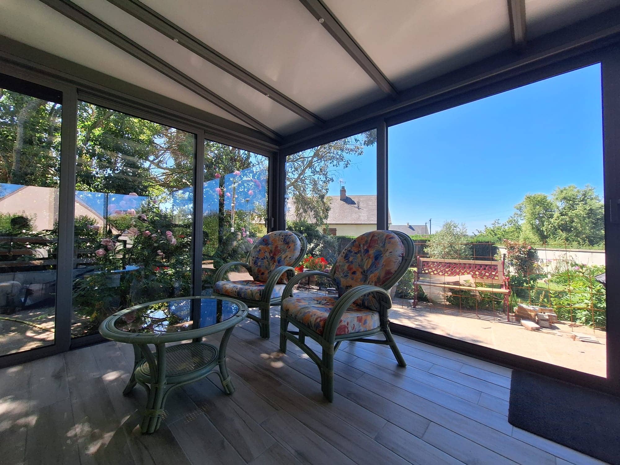 Véranda avec espace détente avec de larges baies vitrées pour profiter pleinement de la vue extérieure