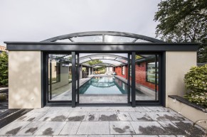 Abri de piscine haut en aluminium avec espace à vivre tout autour de la piscine