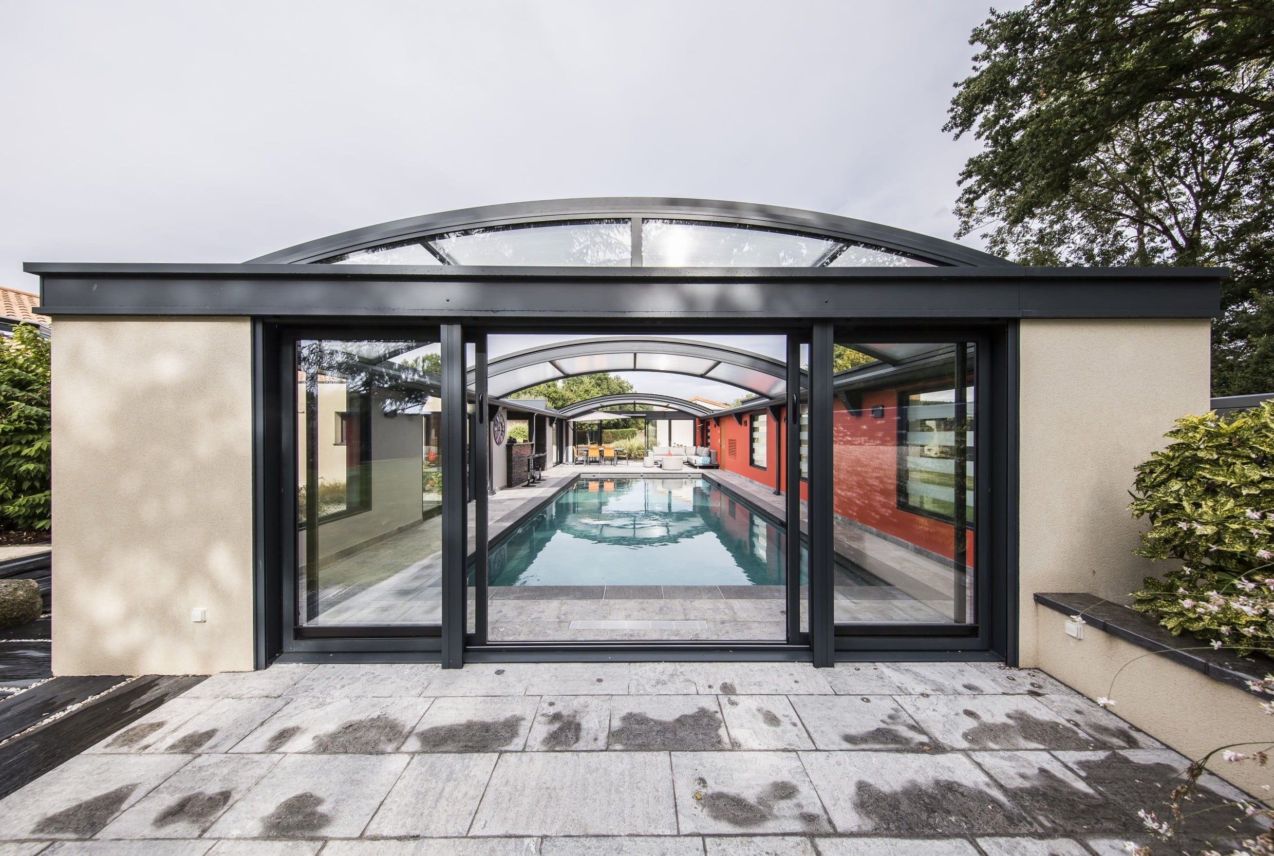 Abri de piscine haut en aluminium avec espace à vivre tout autour de la piscine